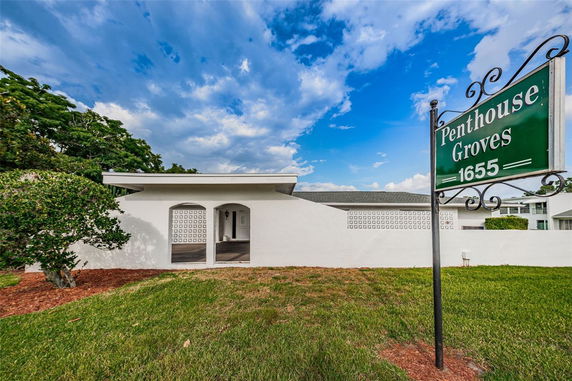 Front view of a single-story building with a sign reading 'Penthouse Groves 1655.'