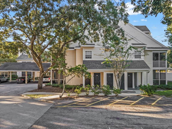 Front view of a multi-story house with a covered parking area.