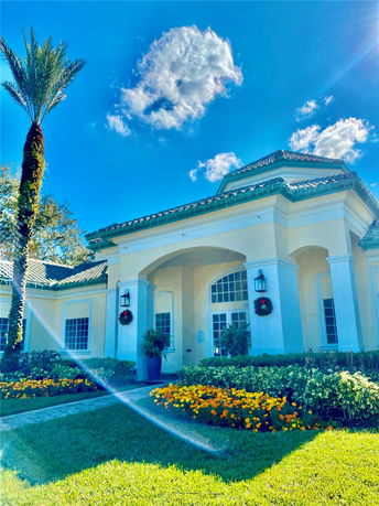 Front view of a house with a tall entrance and decorative plants.