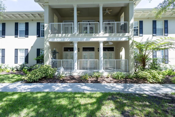 Front view of a two-story house with a large balcony and railing.