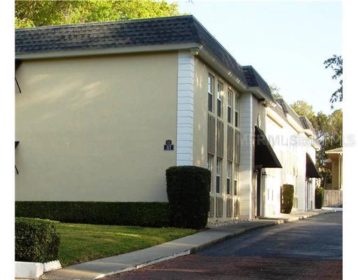 Front view of a two-story building with a flat roof and multiple windows.