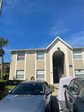 Front view of a two-story apartment building with an entrance archway.