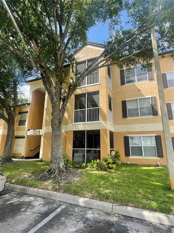 Front view of a multi-story residential building with balconies and large windows.