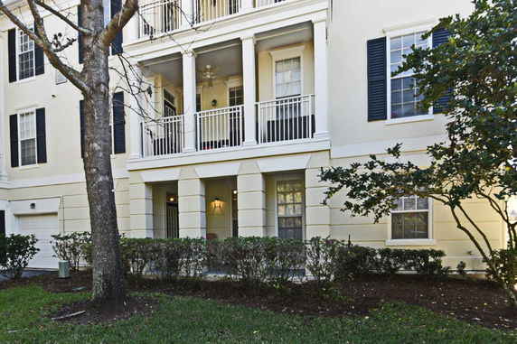 Front view of a multi-story residential building with balconies and garage.