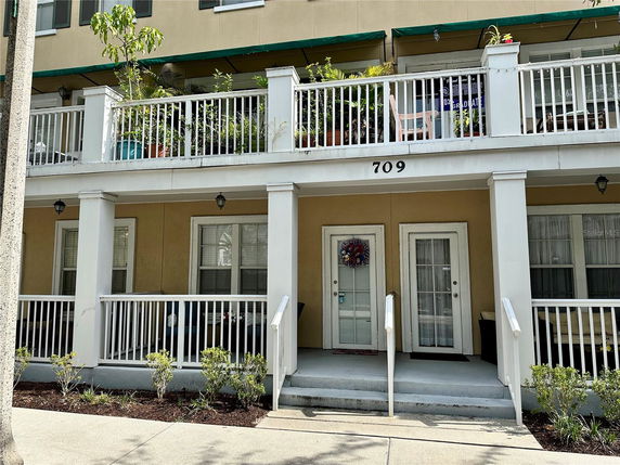 Front view of a multi-story building with balconies and entrances.