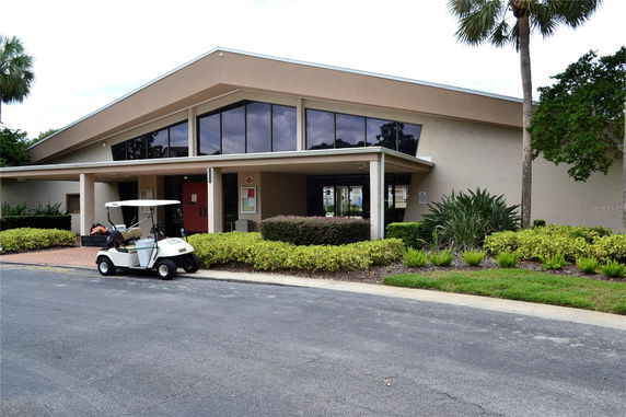 Front view of a modern building with large windows and a sloped roof.