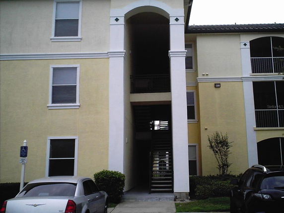 Front view of a multi-story apartment building with a central staircase.