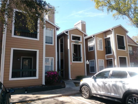 Front view of a multi-story building with wooden siding and multiple windows.