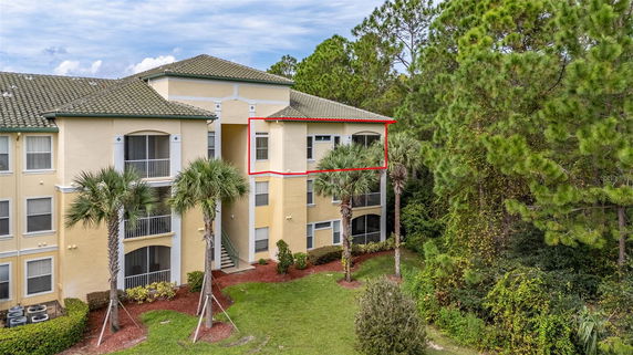 Front view of a multi-story building with balconies and a red highlighted area.