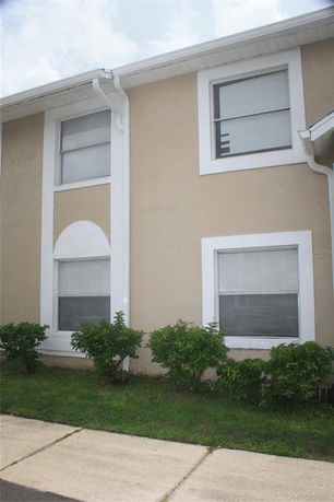 Front view of a two-story building with beige exterior and white trim.