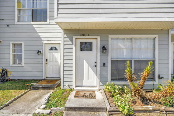 Front view of a two-story townhouse with a white door and gray siding.