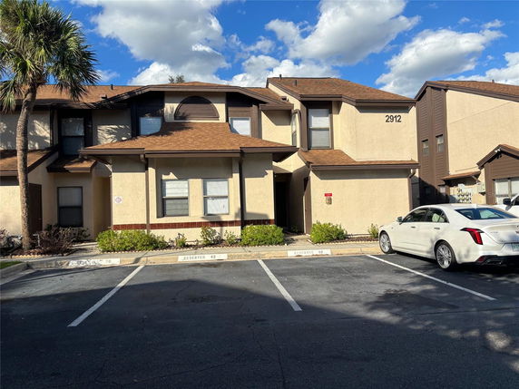 Front view of a two-story residential building with parking spaces.