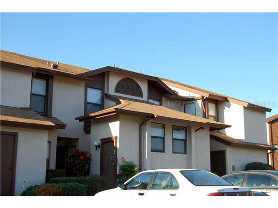 Front view of a two-story townhouse with brown roofing.