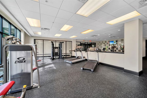 Indoor gym area with exercise equipment including treadmills and a weight machine.