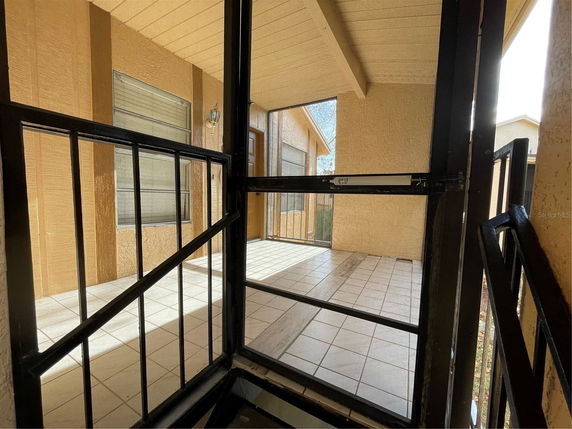 Elevated patio area with tiled flooring and metal railing