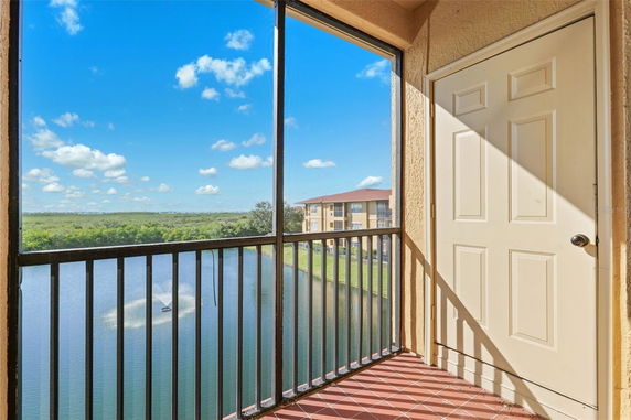 View from a balcony overlooking a water body and distant greenery.