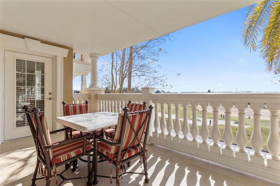 Outdoor balcony with a table and chairs, offering a view of the surrounding landscape.