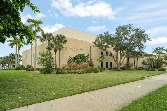 Front view of a modern museum building with a beige exterior and landscaped surroundings.
