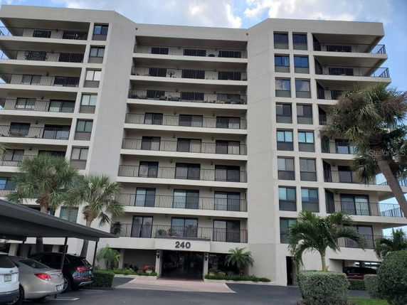 Front view of a multi-story apartment building with balconies.