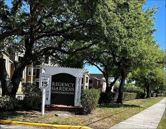 Front view of multi-story condominium buildings with a sign reading 'Regency Gardens Condominiums'.