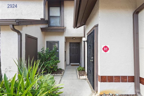 Front view of a two-story house with a pathway leading to the entrance door.