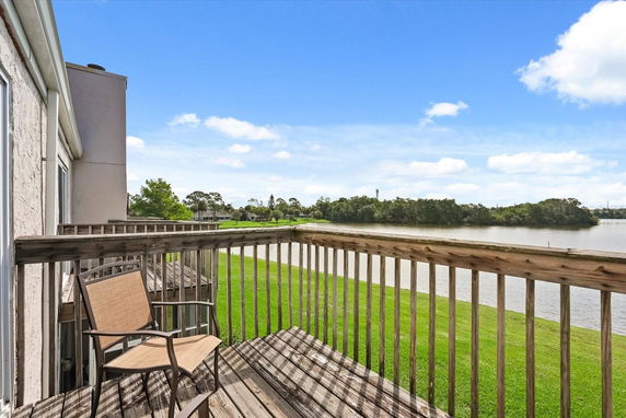 Balcony view overlooking a body of water and greenery.