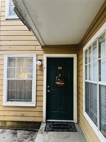 Front view of a house entrance with a door and windows.