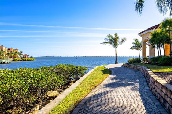 Panoramic view of waterfront properties with a scenic ocean and bridge in the background.