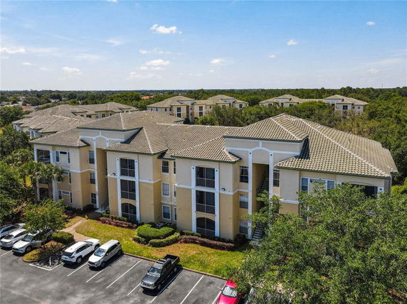 Front view of a multi-story apartment building with a parking area in front.