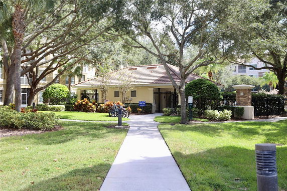 Front view of a small building surrounded by trees and landscaped garden.
