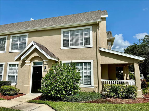 Front view of a two-story house with a simple porch and multiple windows.