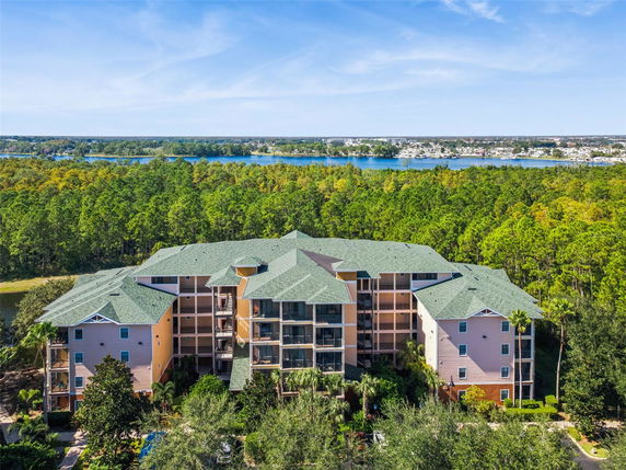 Front view of a multi-story residential building surrounded by trees.