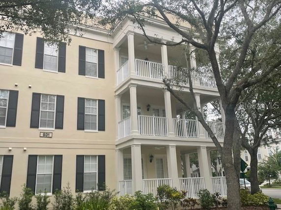Front view of a multi-story building with multiple balconies and black shutters.
