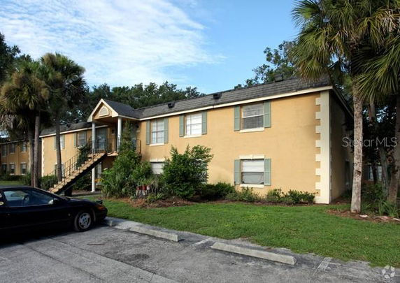Front view of a multi-story residential building with external staircase.