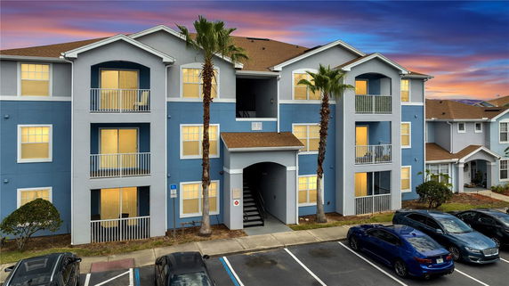 Front view of a multi-story apartment building with blue and white exterior.