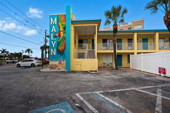 Front view of a two-story building with colorful mural and balcony.