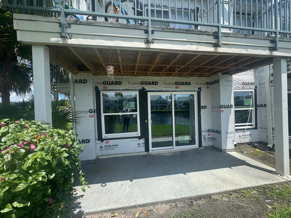 Exterior view of a building under renovation with protective sheathing.