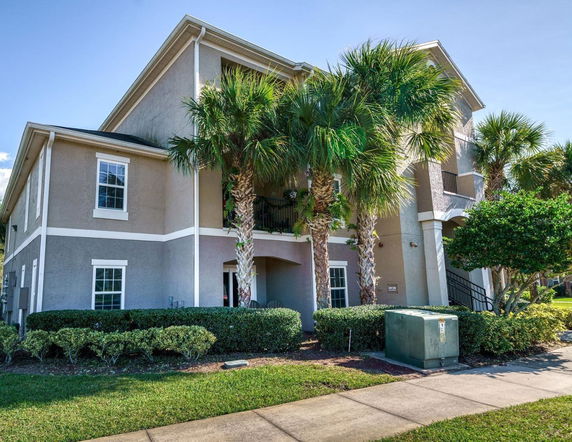 Front view of a multi-story building with palm trees.