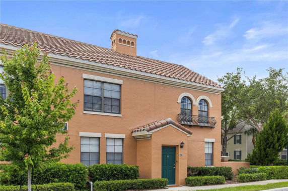 Front view of a two-story house with a tiled roof and arched windows.