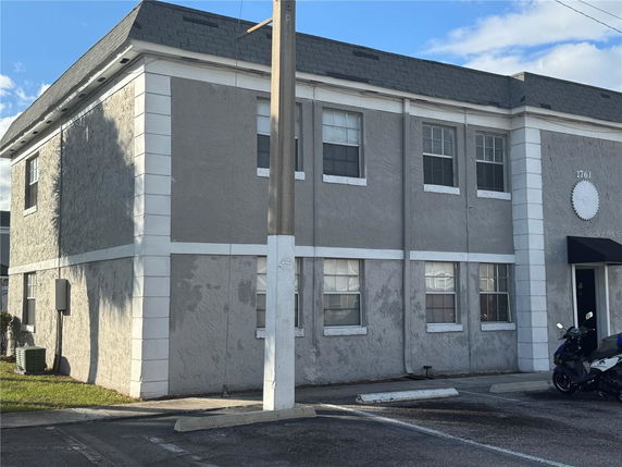 Front view of a two-story building with a flat roof and multiple windows.