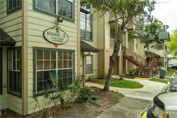Front view of a multi-story apartment building with balconies and stairs.