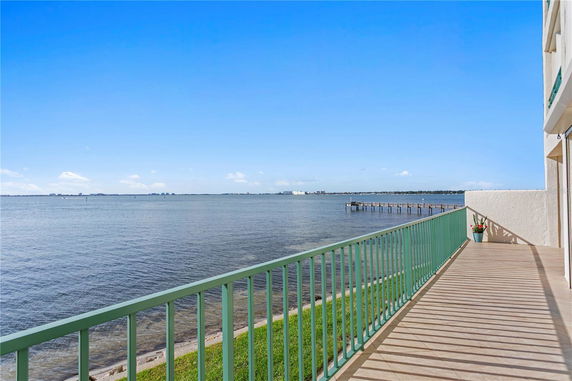Panoramic view of a waterfront balcony with railing overlooking the ocean.
