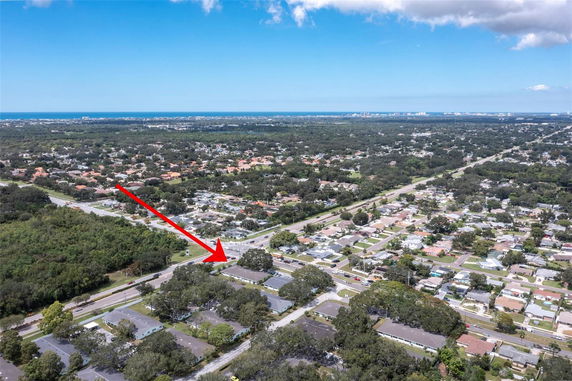 Panoramic aerial view of a residential area with a distant ocean skyline.
