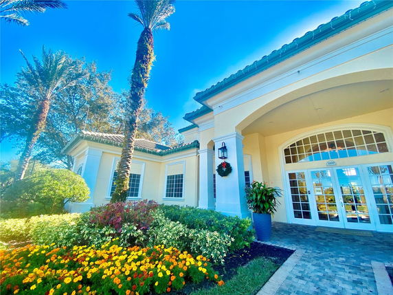 Front view of a house with decorative arches and large windows.