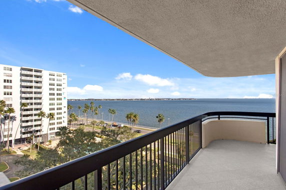 View from a balcony overlooking a large body of water with a distant shoreline.