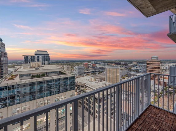 Panoramic view of a cityscape from a balcony at sunset.