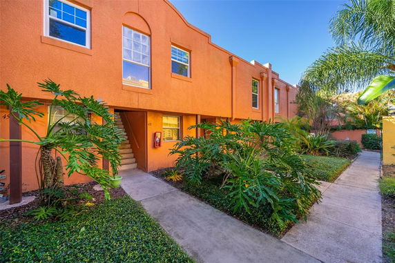 Front view of an orange multi-story residential building with stair access.