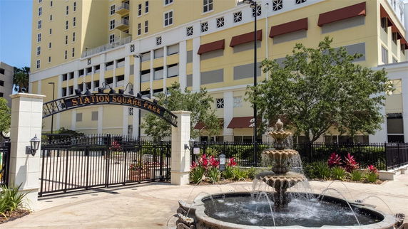 Front view of a multi-story yellow building with an entrance gate labeled 'Station Square Park'.