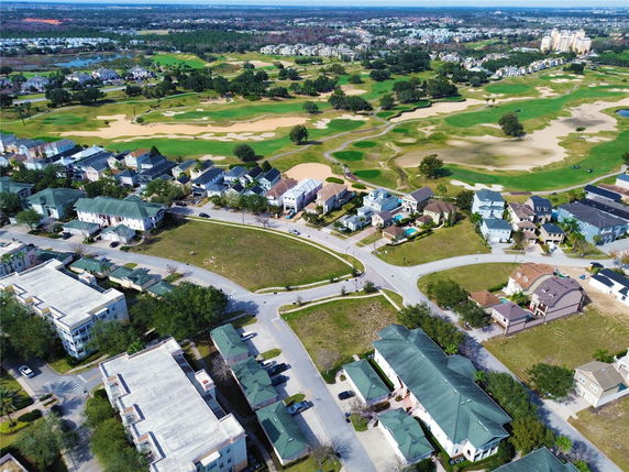 Aerial view of suburban houses and a golf course stretching into the distance.