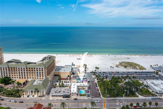 Panoramic view of buildings by the beach with a wide ocean backdrop.
